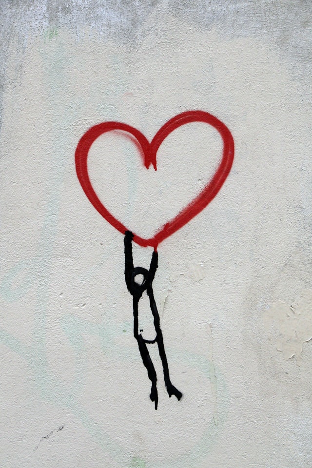 Drawing of a stick figure hanging onto a heart