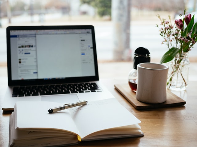 set up workspace with open laptop and open journal; demonstrating hard work